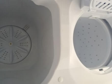 Links wastrommel en rechts centrifuge trommel van een mini wasmachine. De centrifuge trommel heeft gaten aan de zijkanten, de wastrommel niet.